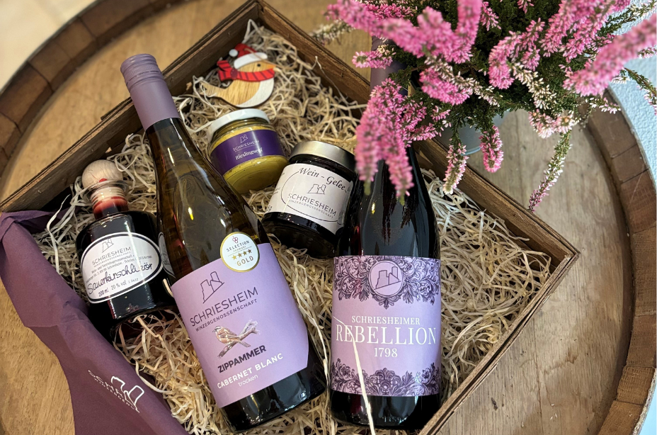 Zwei weinflachen im Korb mit  Senf, Likör und Gelee